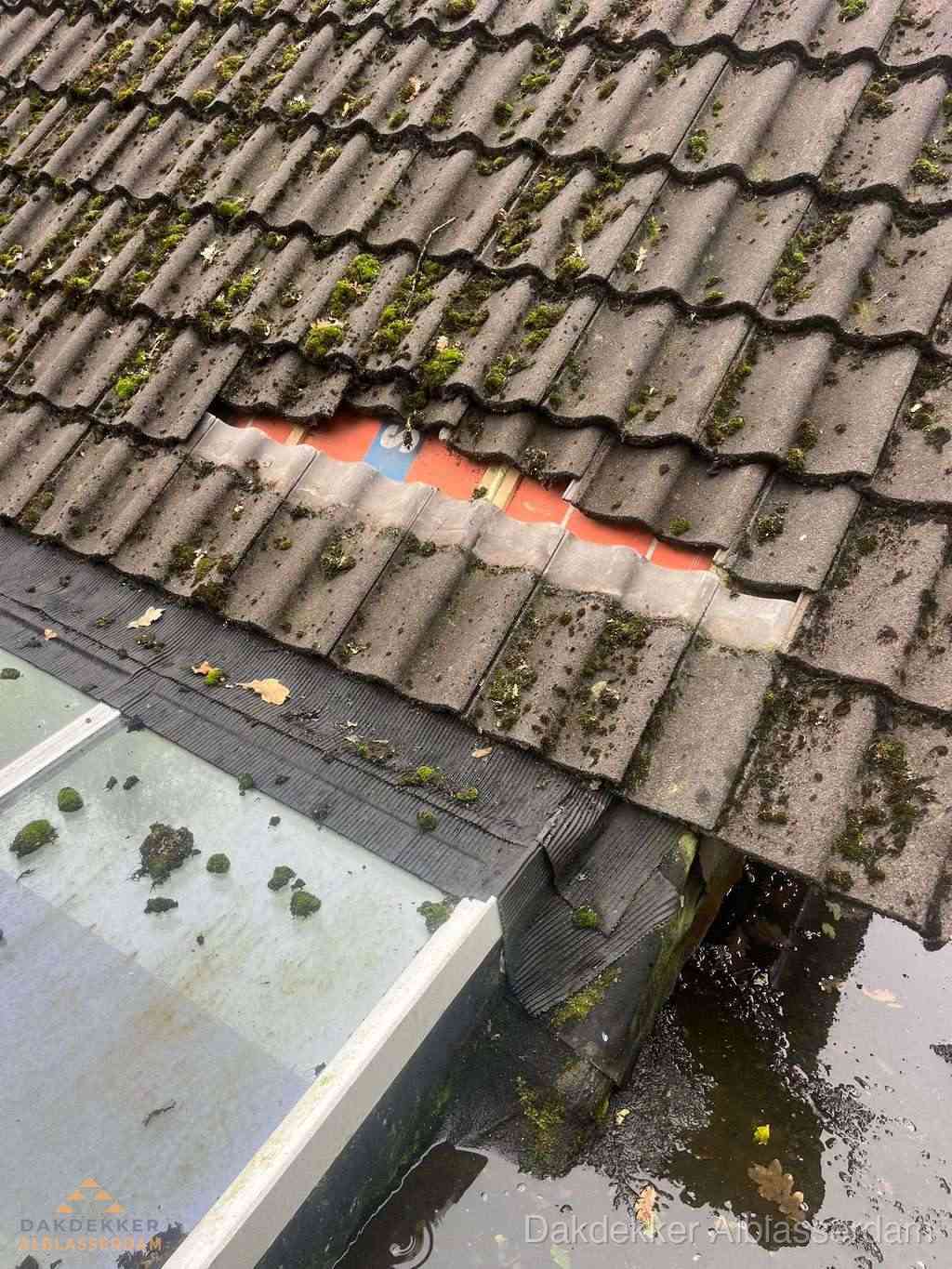 Beschadigd pannendak met ontbrekende dakpannen voor reparatie in Alblasserdam