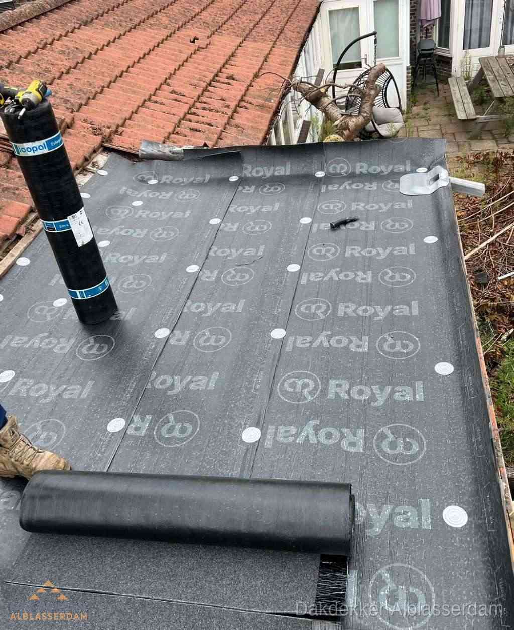 Plat dak met nieuwe bitumen dakbedekking en brandgereedschap in Alblasserdam