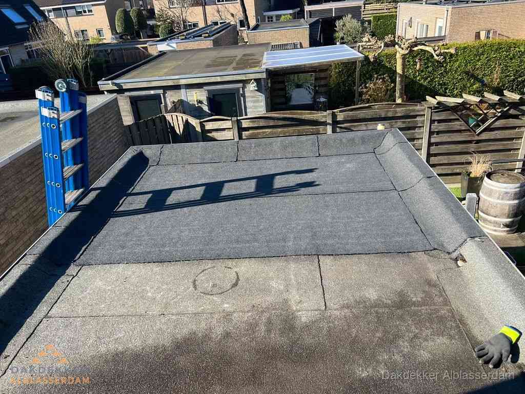 Dakdekker legt onderlaag op plat dak met houten constructie in Alblasserdam