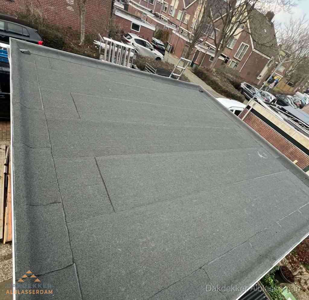 Nieuwe bitumen dakbedekking op plat dak van garage in Alblasserdam