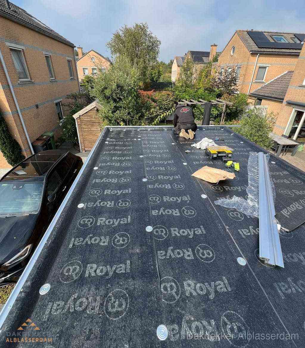 Dakdekker aan het werk op plat dak renovatie in Alblasserdam