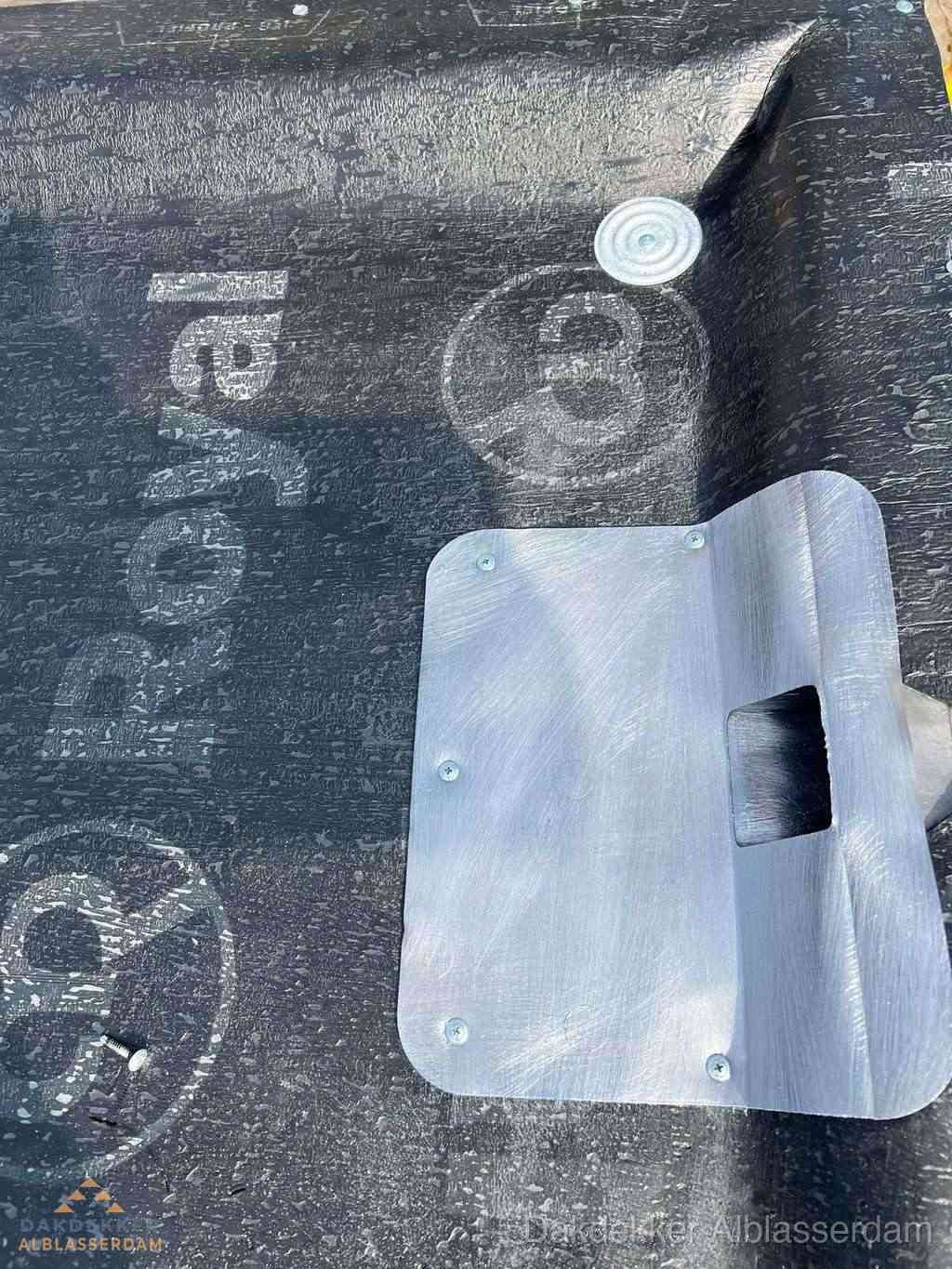 Dakdoorvoer met metalen afvoerplaat op bitumen dak in Alblasserdam