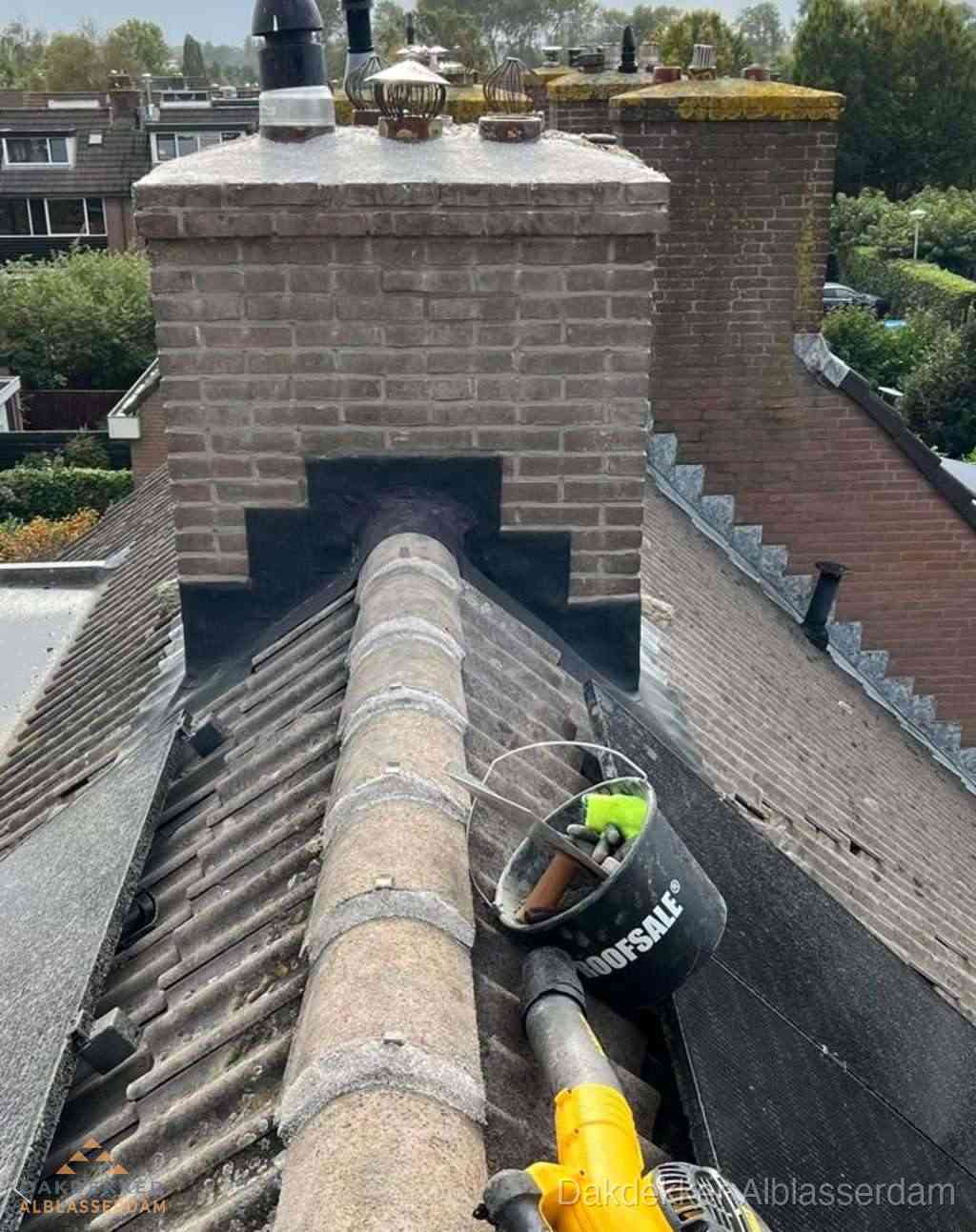 Dakdekker repareert bitumen dakleer bij dakdoorvoer in Alblasserdam